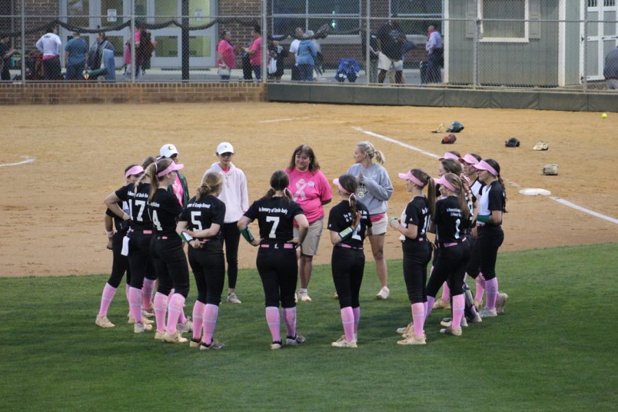 The varsity softball team talks after beating Monticello 5-0 on breast cancer awareness night. 