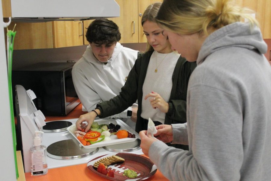Juniors Austin Talley, Dallas Sprouse and Emily Gillespie make a healthy charcuterie board as a better Super Bowl snack option. 