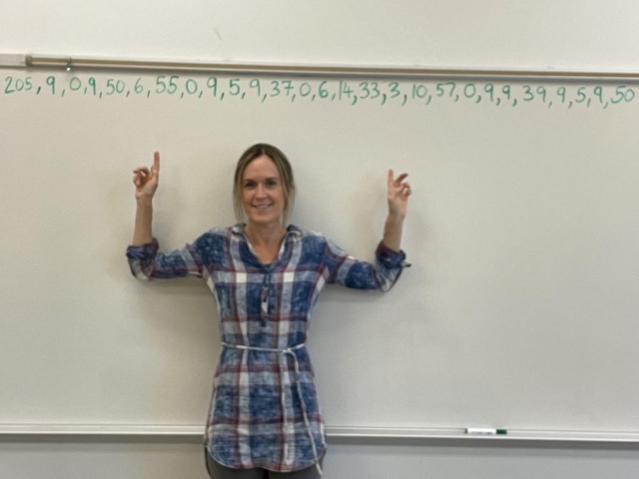Kate+Fletcher+pointing+to+her+mileage+run+board+in+her+classroom.+