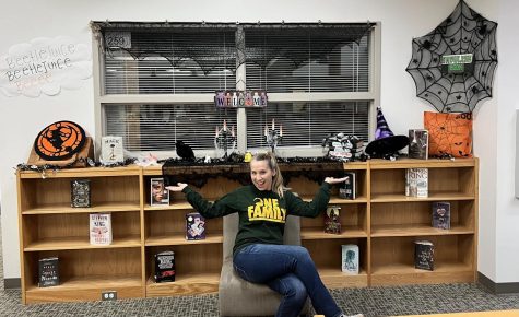 Tech Coach, Mrs. Wagoner represents the Halloween decorations in the Library.