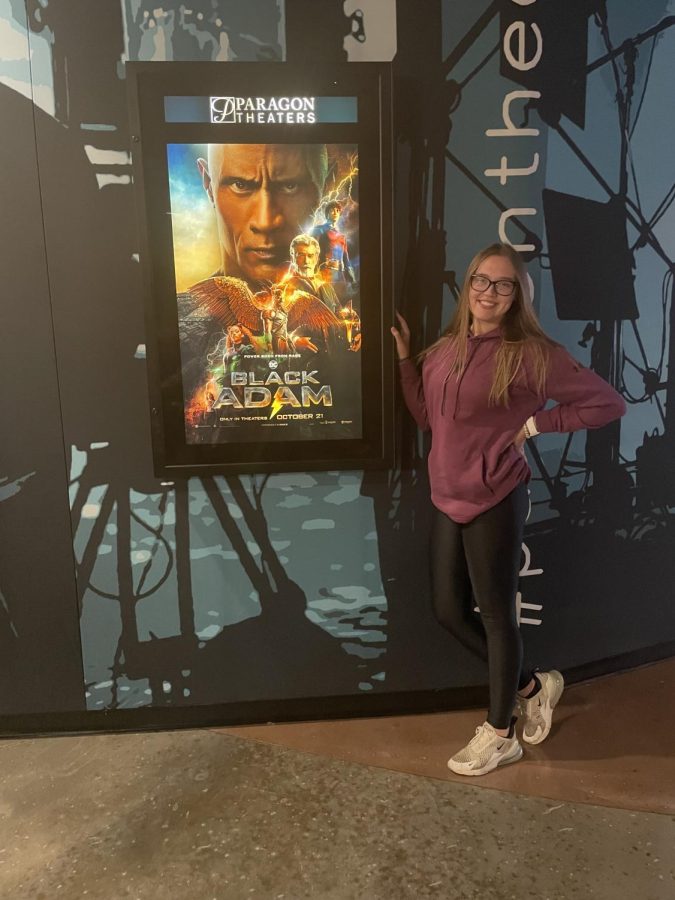 Editor in Chief, Ashlynn Harding poses in front of the Black Adam sign at the Paragon movie theater in Spotsylvania. 