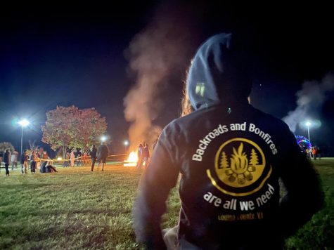 Image featuring the 2020-2021 Leadership bonfire shirts and event held at the marching band practice field. 