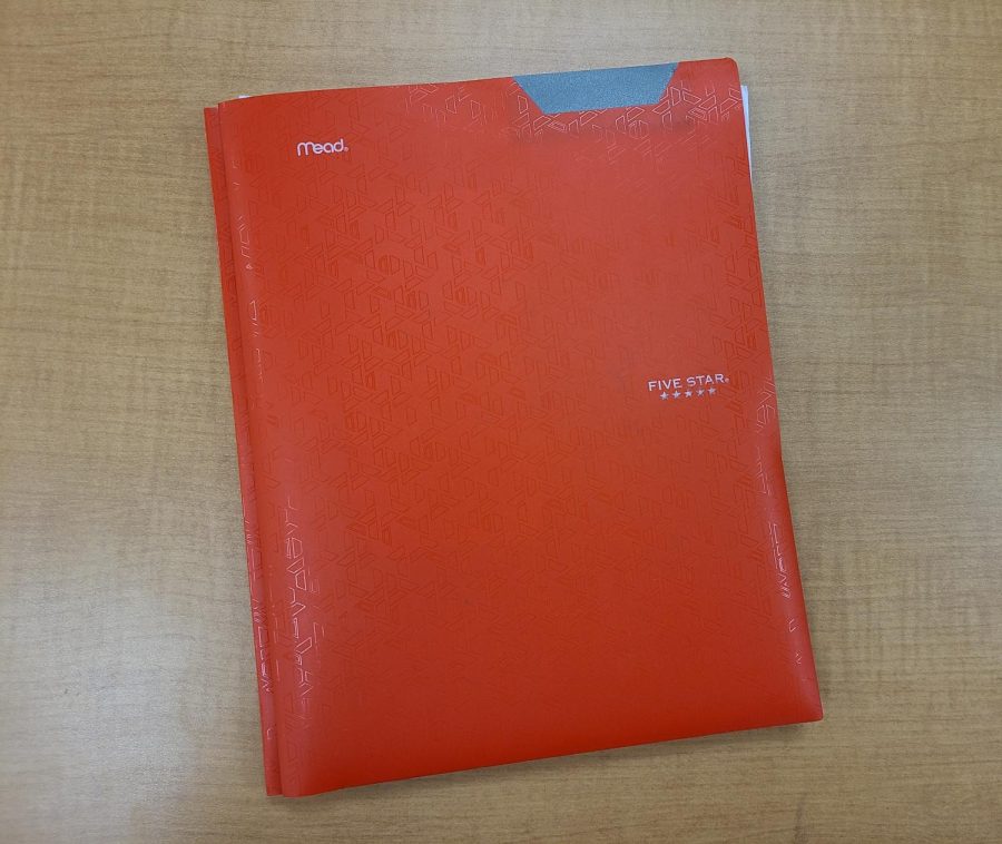 This photo features writer, Joss Jones, red folder that is used specifically for math class.