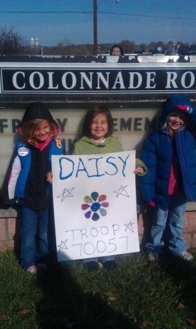 Ashley N., Casey Little, and Porschia M. holding a troop sign for the Veterans Day Parade. 