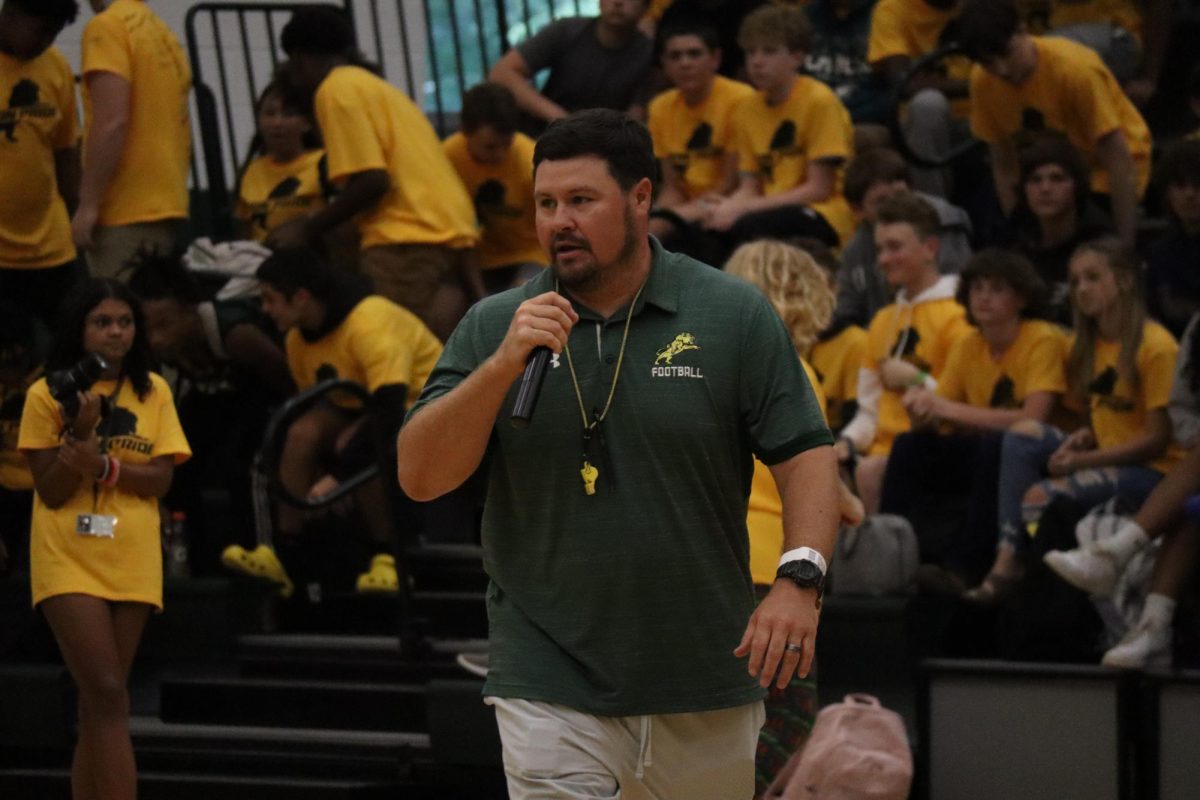 Football coach William Patrick giving an inspiring and exciting speech during the pep-rally.