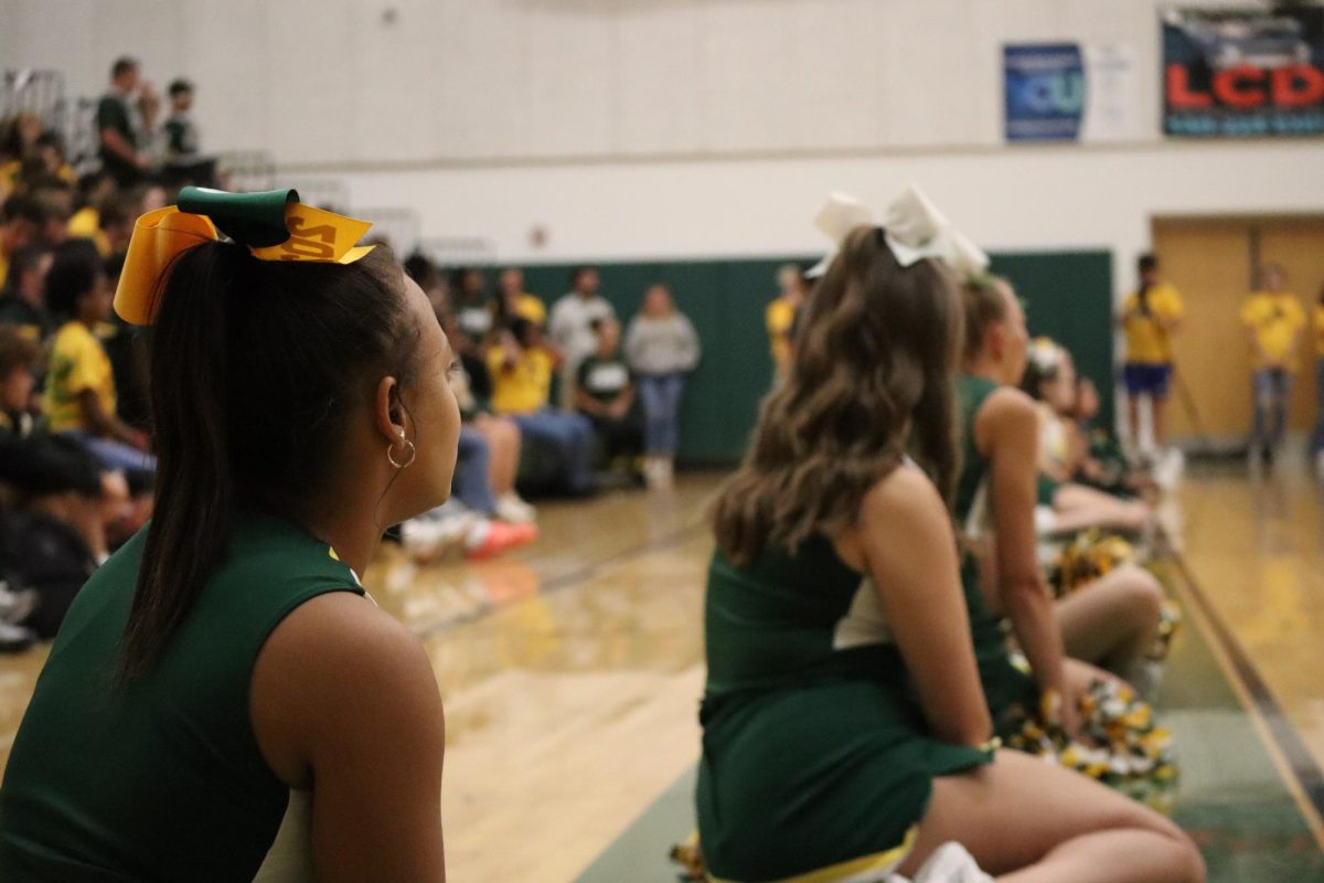Cheerleaders admiring the speech coach William Patrick gives to the students before the first home football game.