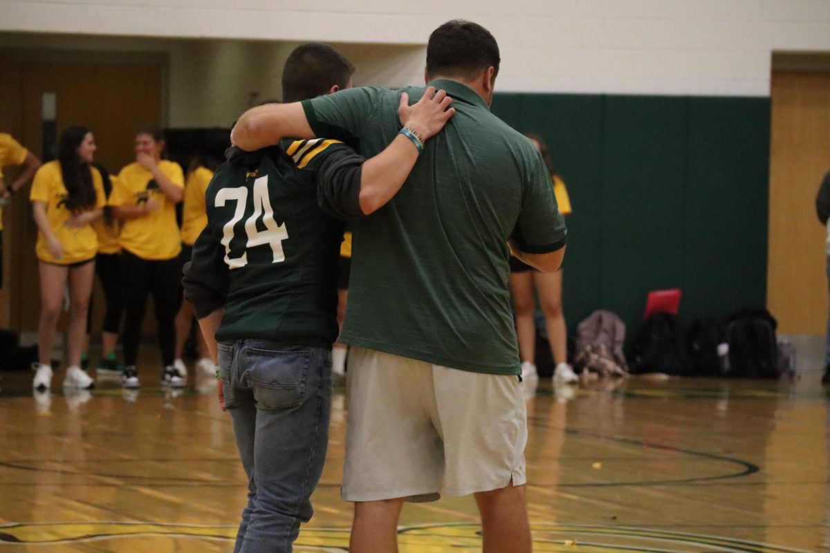 Gabriel Froschauer and Coach Patrick hugging during sentimental speech to get students excited for game.