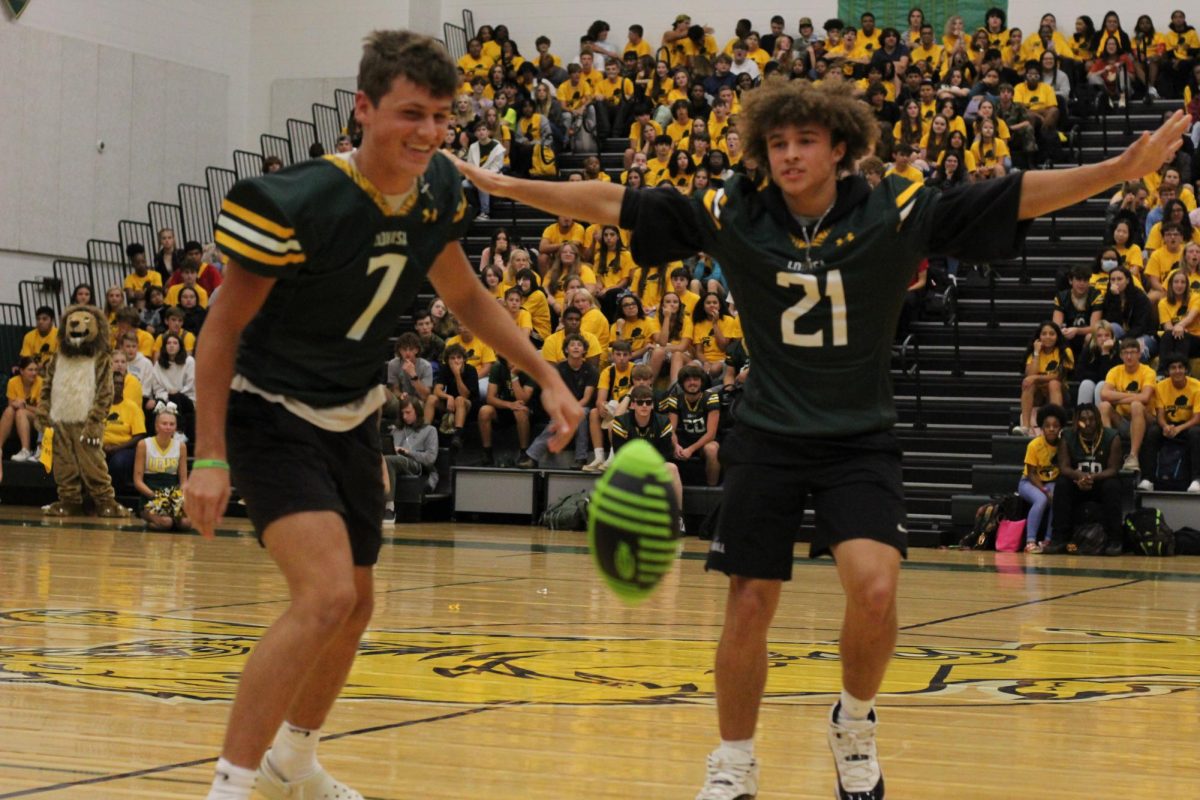 Football player Isaiah Holland guarding teammate Austen Grady during dizzy football at the Pep-rally