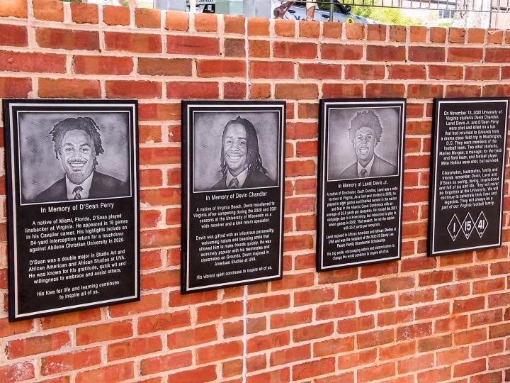 Four plaques hang at the south end of the UVA football field in honor of Dsean Perry, Devin Chandler and Lavel Davis Jr. (left to right).