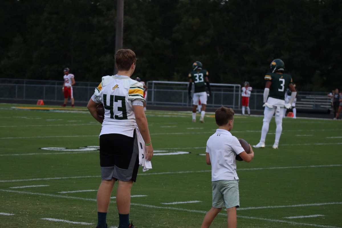 Junior Varsity player, Mikey Pelloni and Reese Patrick watching the players before kickoff.
