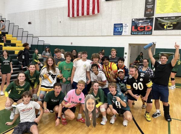 The varsity volleyball teams student section celebrating together after their win against Spotsylvania.