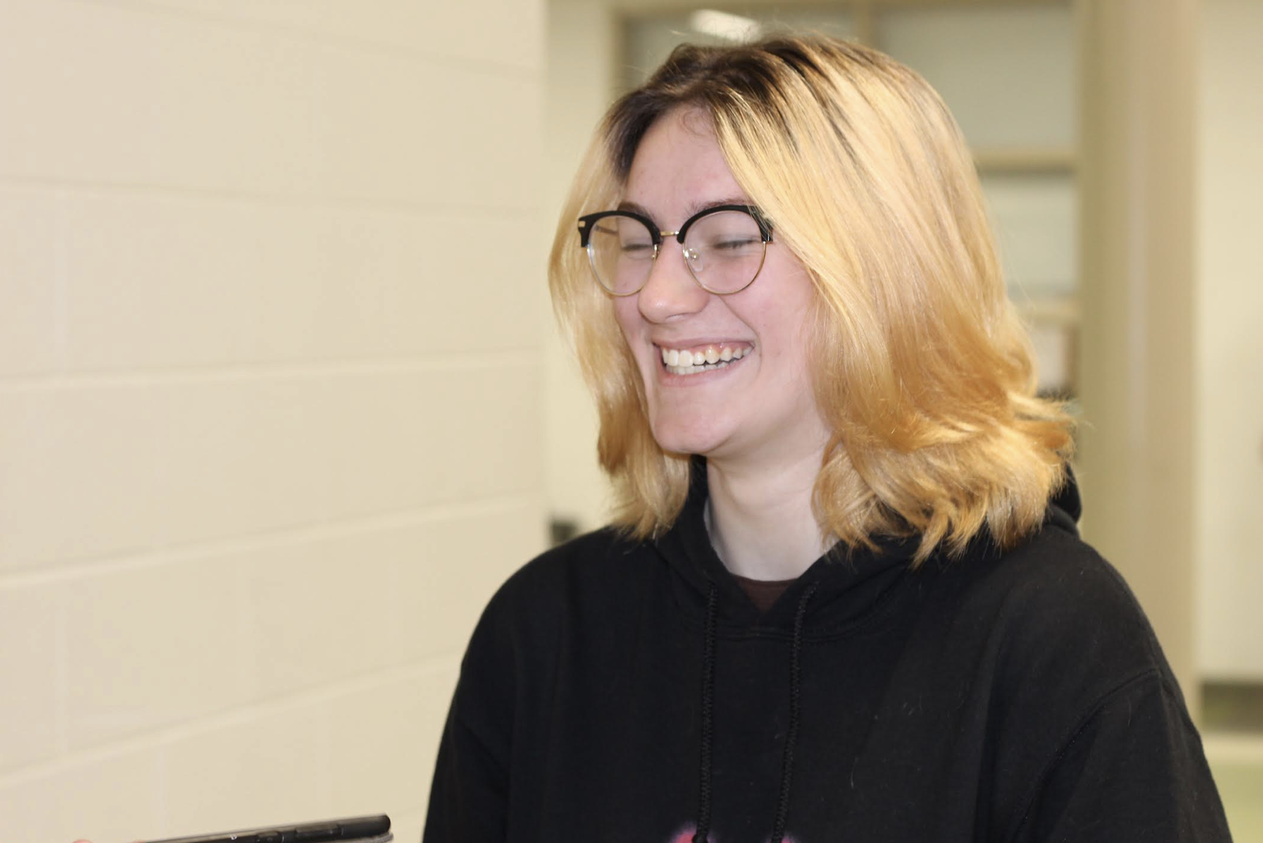 Photo of sophomore Lisa Schweyer as she smiles and laughs in the hall.