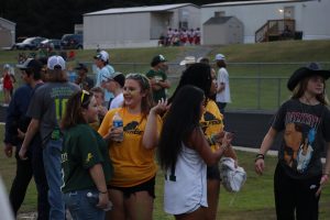 A group of sophomores is depicted sporting their green and gold at the first varsity home game of the season.
