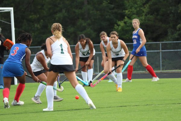 Junior varsity players defending their goal together against Caroline while they try to score a point.