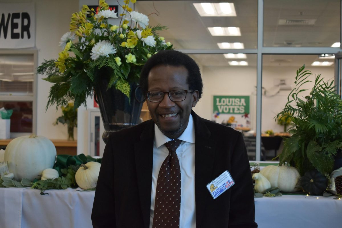 Anthony McClendan, a Louisa County voter representative, smiles for a photo at his booth.