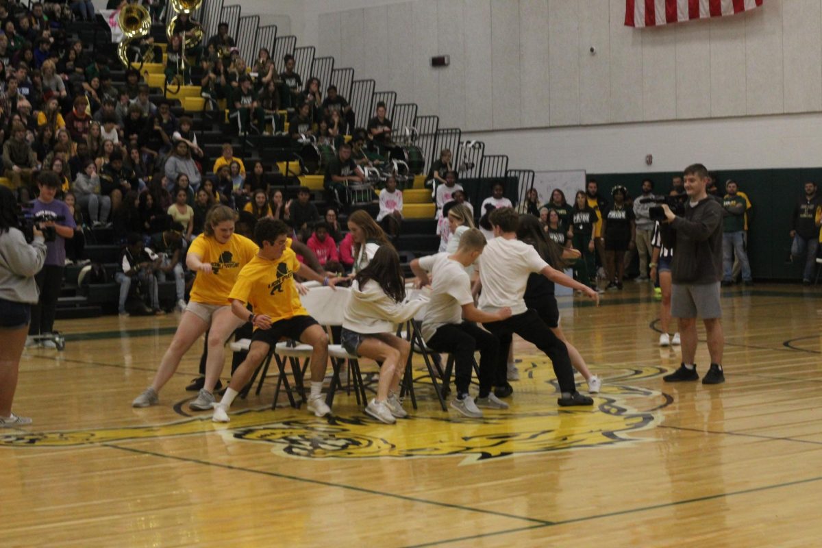 Students rush to find a seat during a game of musical chairs at the pep-rally.