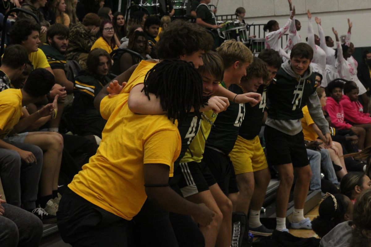 Senior student section celebrating in arms together after their win during pep-rally.