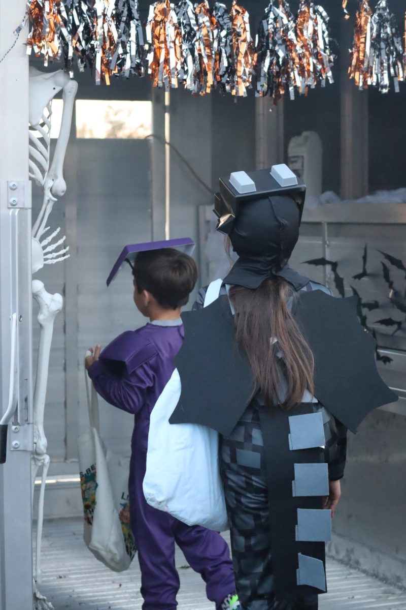 Minecraft themed trick or treaters walk into the kids haunted house on wheels. 