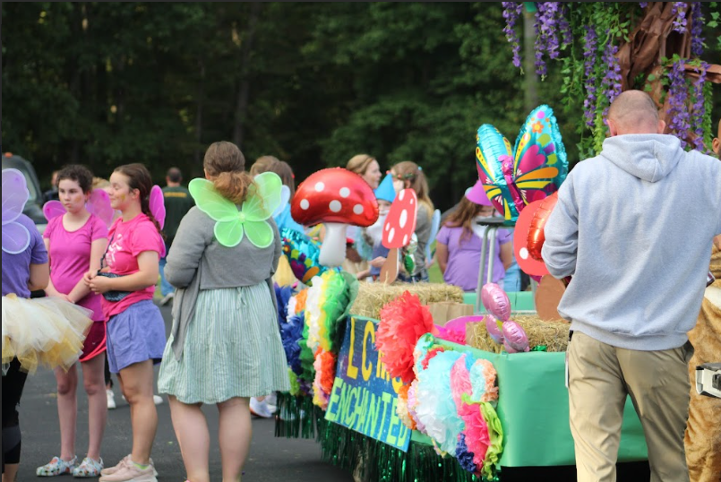 Community members in colorful fairy costumes cooperate in anticipation of the Hometown Homecoming parade.