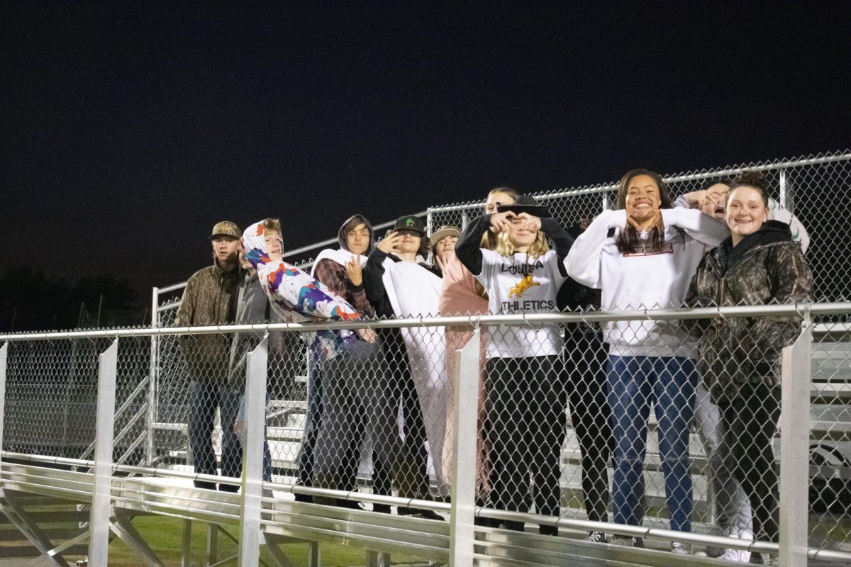 Students pose for a picture in the student section during the sophomore and senior game.