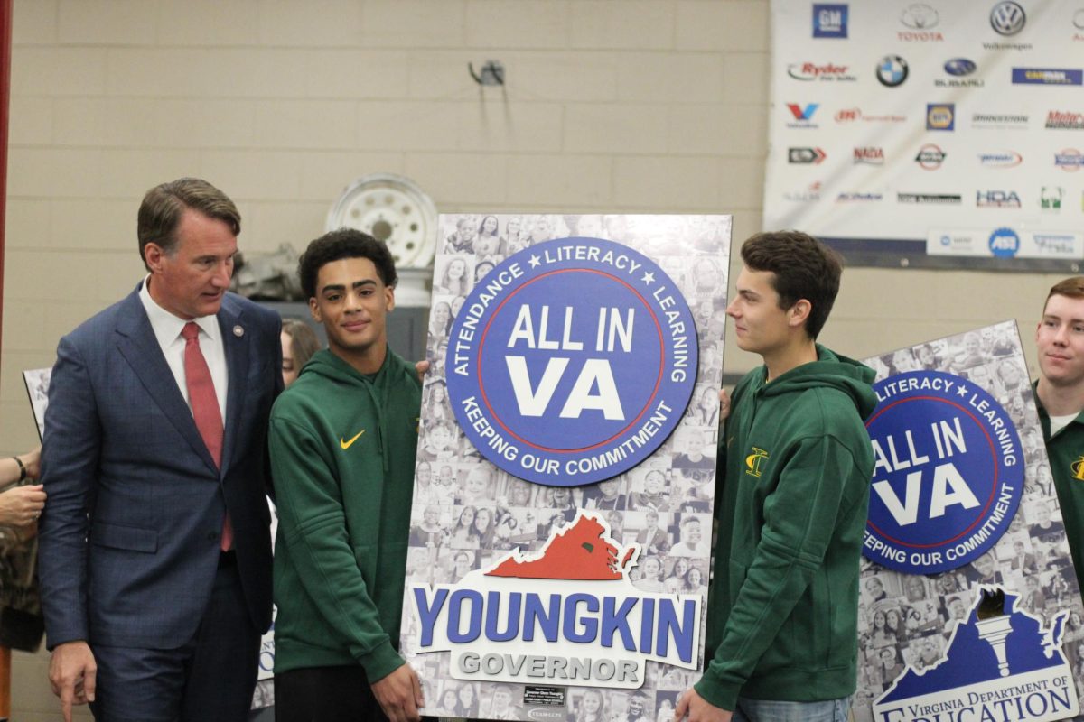 Students Eric Davis and Connor Downey posing with Youngkin and the All in VA poster.