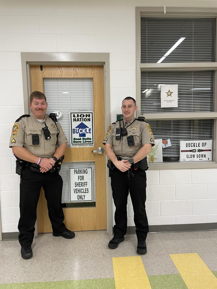Sergeant Harris and Corporal Shreve pose for a photo outside their office after an interview.