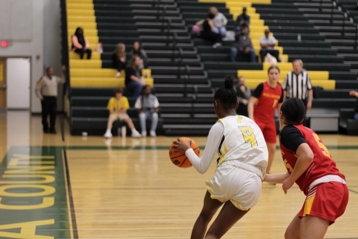 8th grader, Laila Anthony, dribbles through defenders to make a shot. 