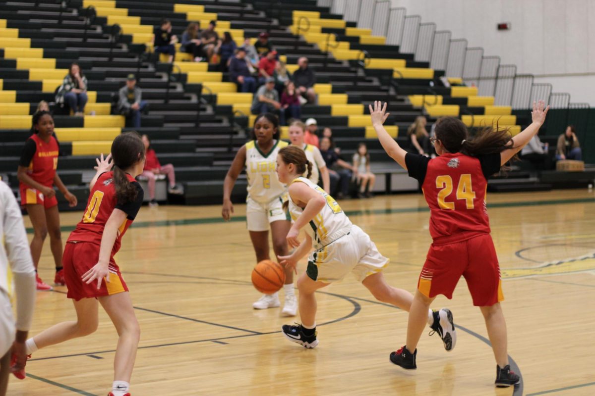 Point guard, Hailey Chiles, dribbles her way through the game to make a shot.