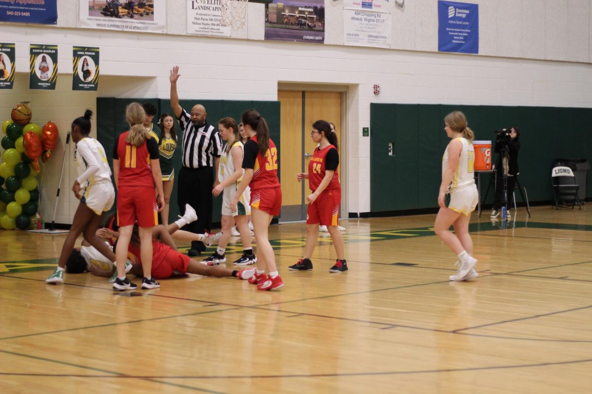 All players standing around in the paint after the referee made a call. 