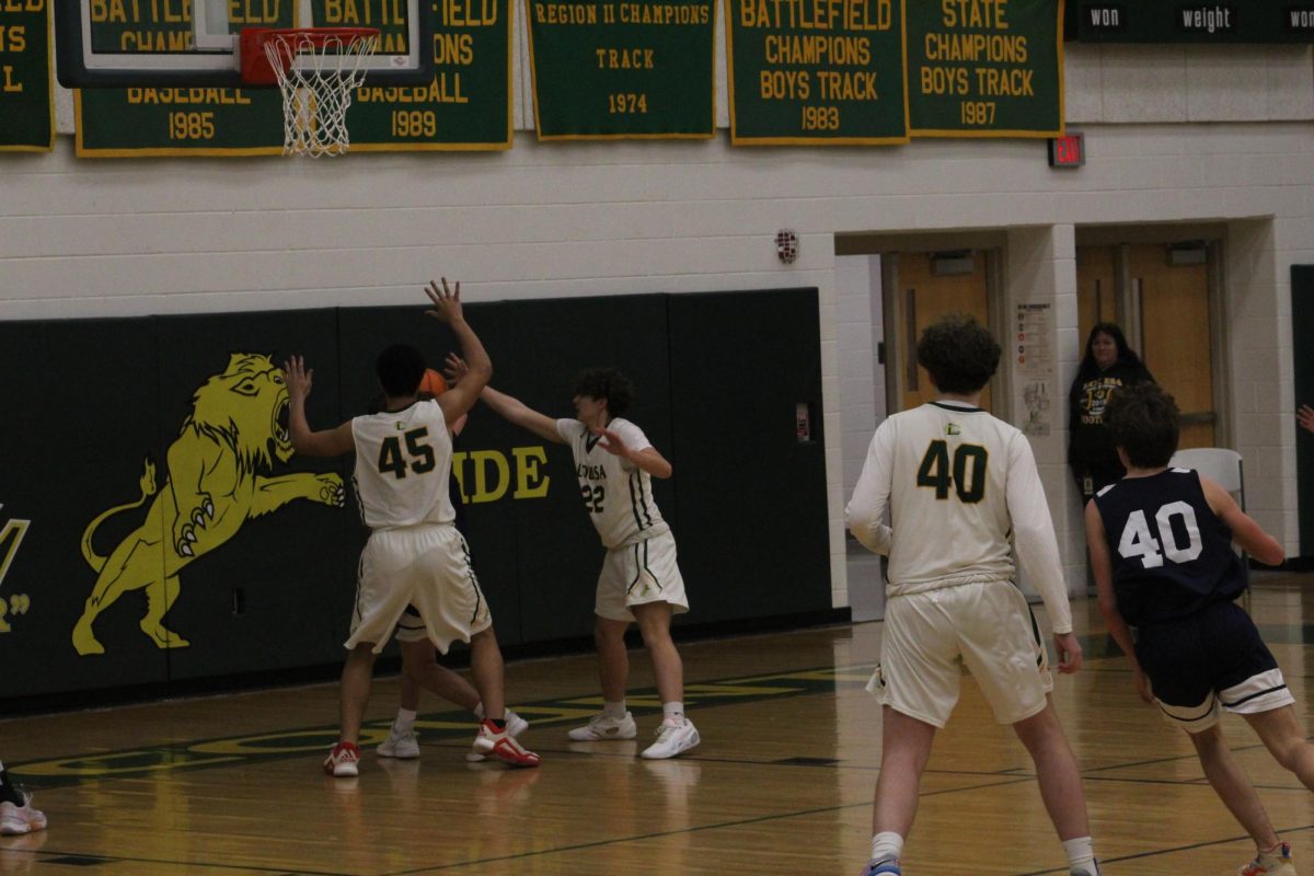 Killian Uhlman and Isaiah Wright trapping the ball underneath the basket. 