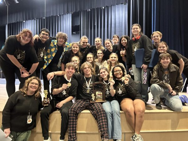 Mainstage students pose on the stage after winning the Region 5C championships with their medals and trophy. Courtesy of Jelita Perry.