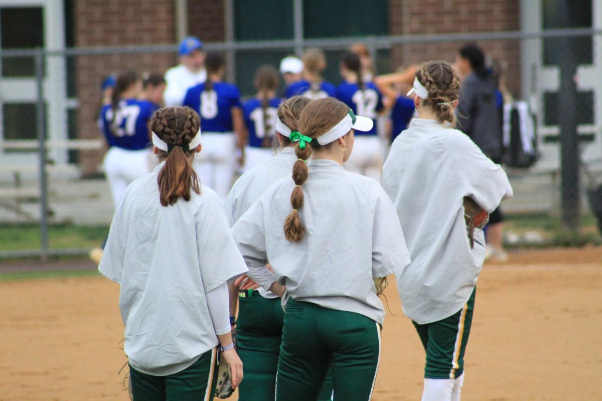 Softball player waiting in a line during warmups before the game. 
