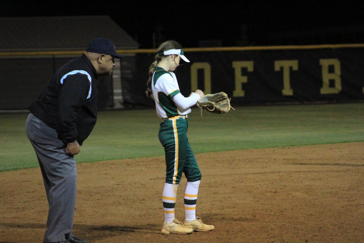Shortstop Savannah Bragg looking at her play call wristband between pitches.