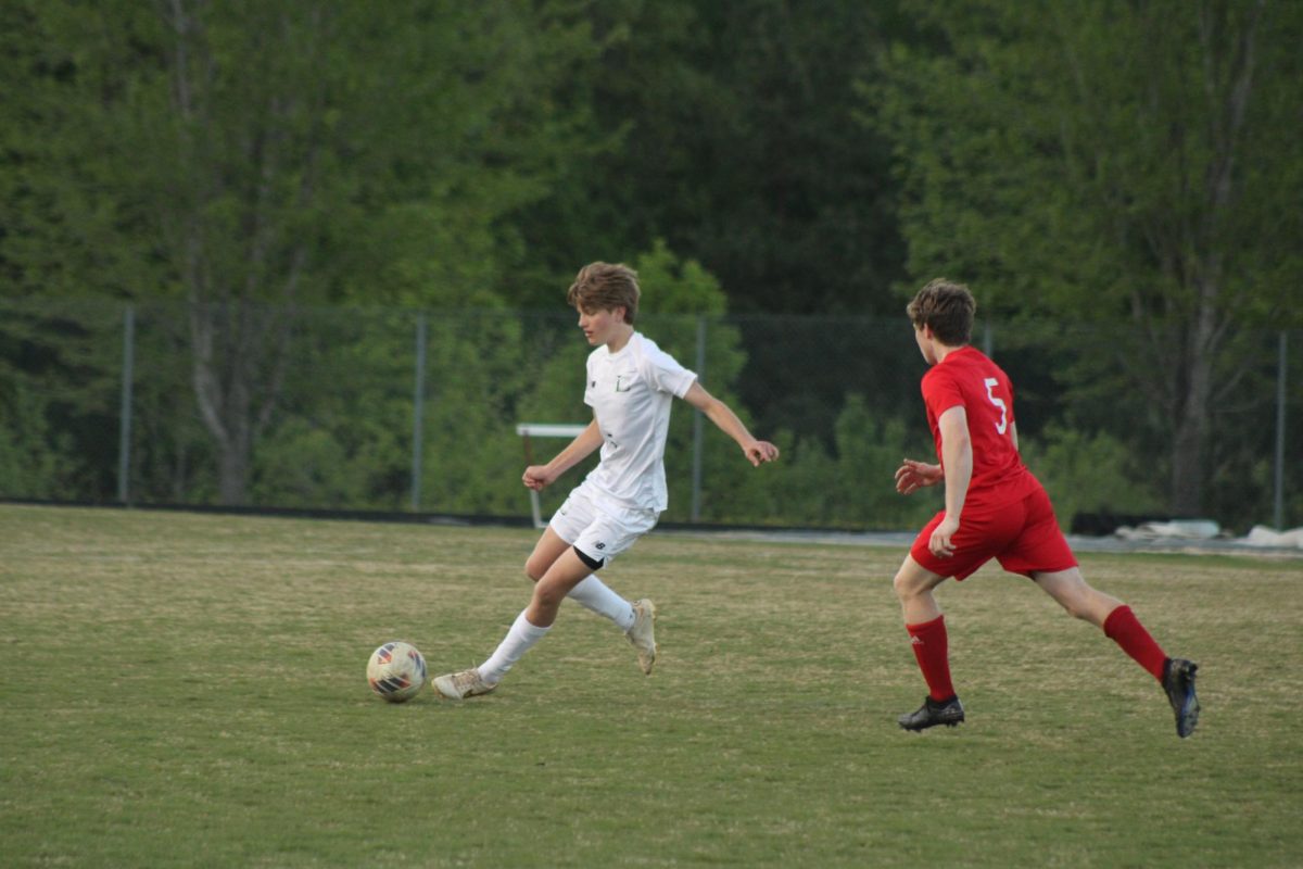 #5 Hudson MacDougall kicking the ball away and passing to a teammate.