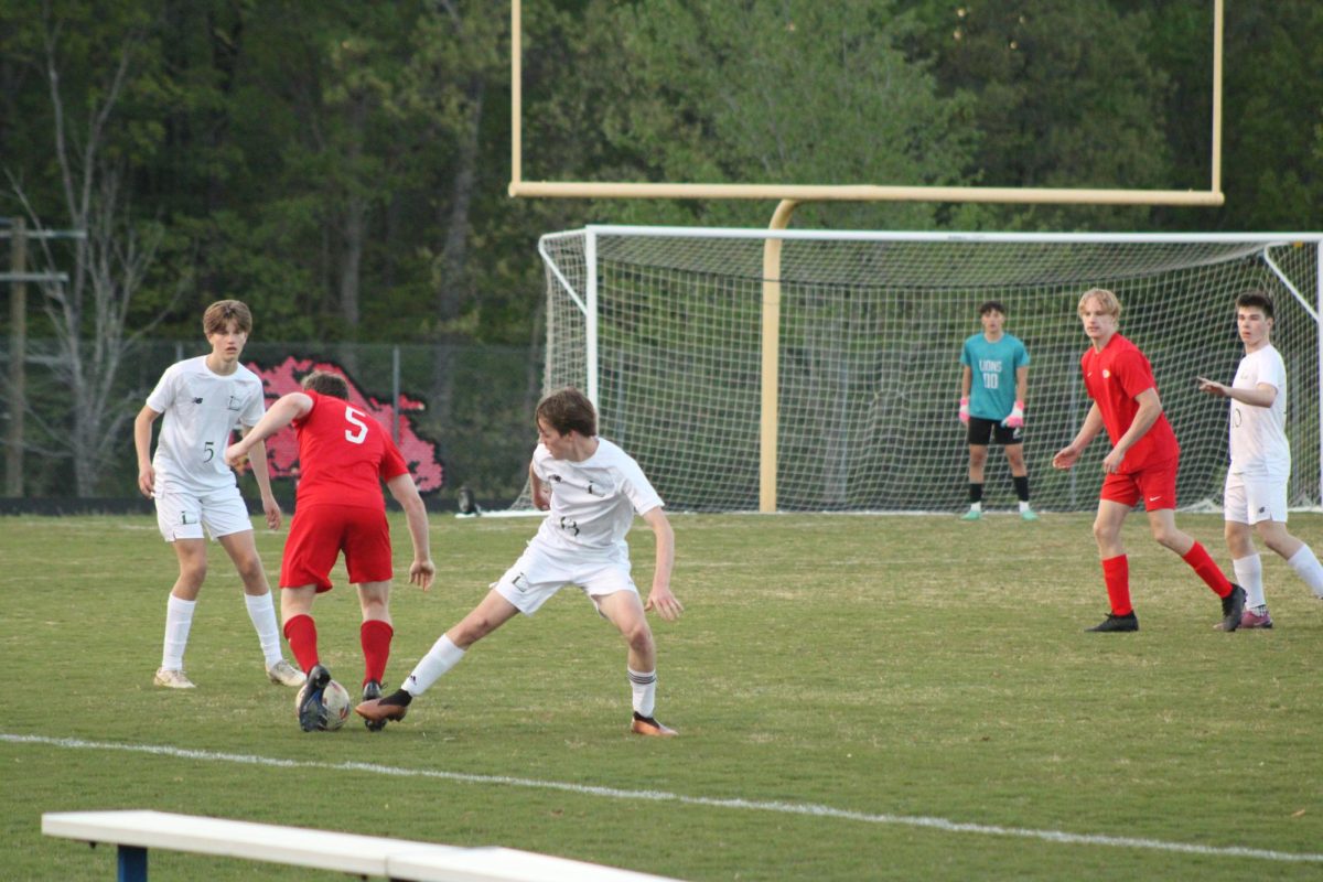 Junior players, Finn Jennings #13 and Hudson MacDougall, defending the ball from attacking Goochland players.