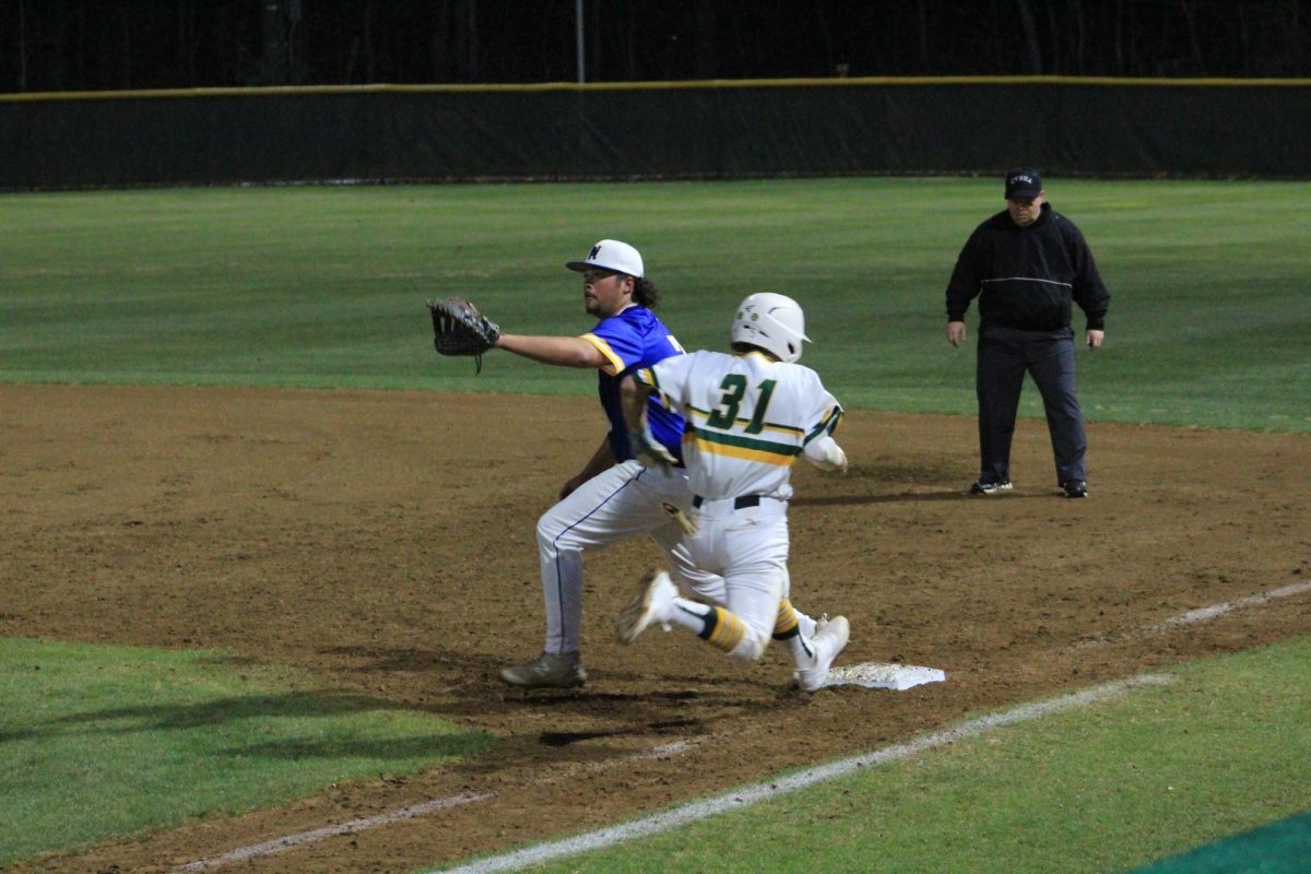 Senior Elijah Best running to first base while the ball is being thrown. 