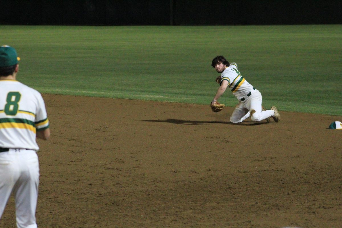 Senior DJ Harlow on the ground about to throw the ball to Connor Downey to get the runner out.
