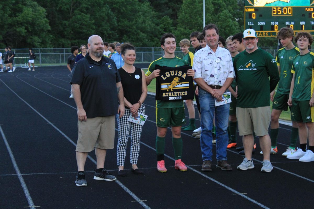 Senior Parker Harman posing for a picture with his parents on senior night. 