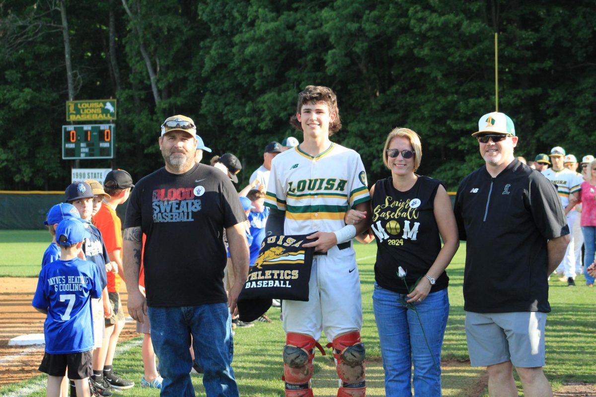 Senior Cody Fifer posing for a picture with his parents on senior night. 