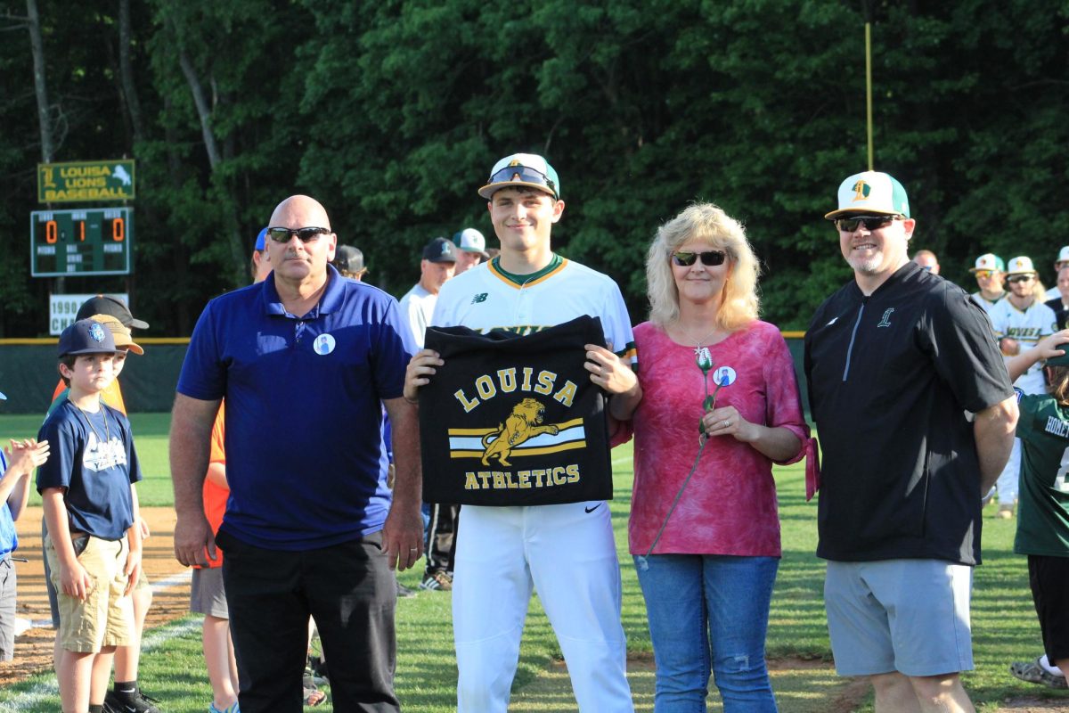 Senior Austen Grady posing for a picture with his parents on senior night. 