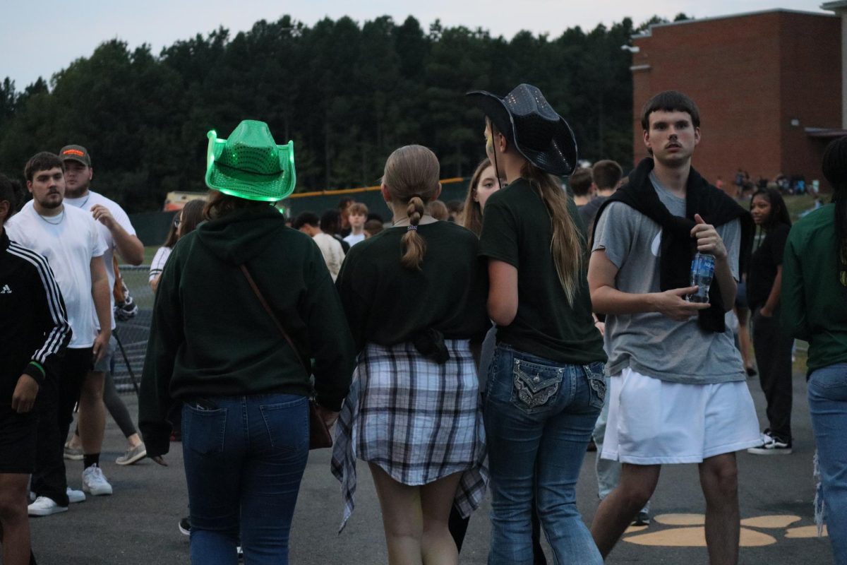 Students dressed in their green and gold walking around before kickoff of the first home game.