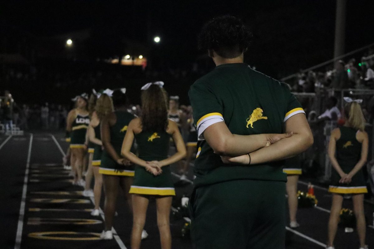 Cheerleader Dominic Judy stands in formation with the rest of the team.