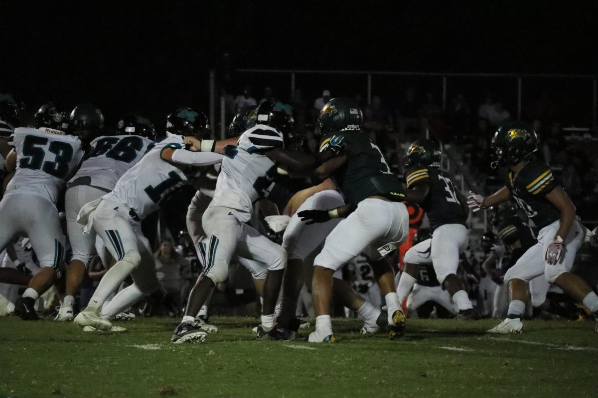 Louisa athletes attempt to tackle Massaponax players with the ball.