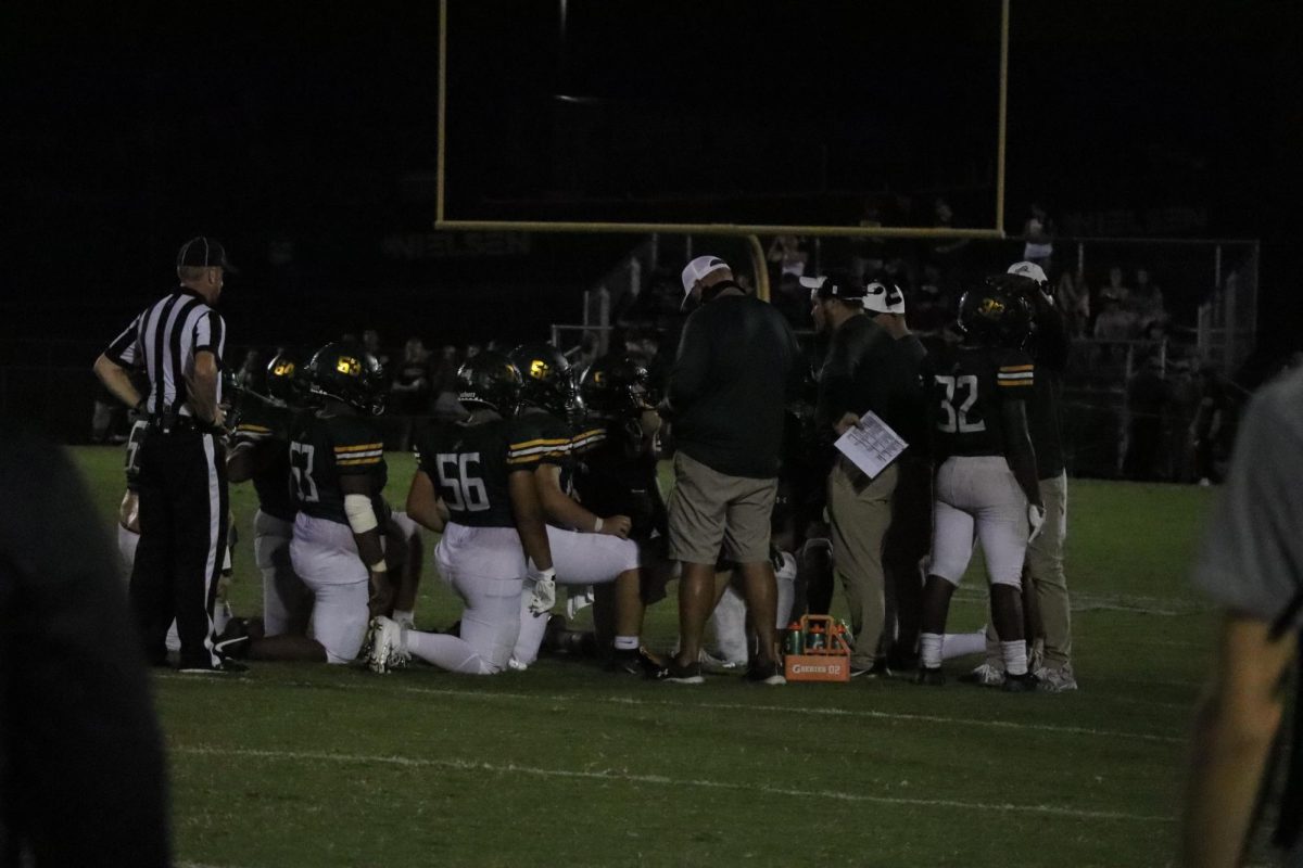 The Louisa players listen to their coach giving a speech before going into the last quarter of the game.