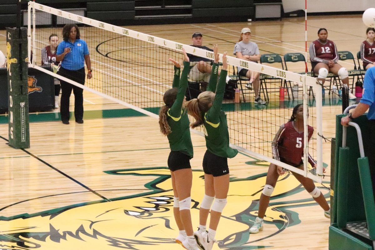 Freshman Duo Fallon Ellis and Charlee Miller prepare to block the ball.