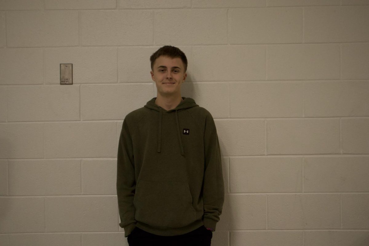 Sophomore Colin Gibson smiles in the hallway after talking about his enjoyment for floor hockey club.