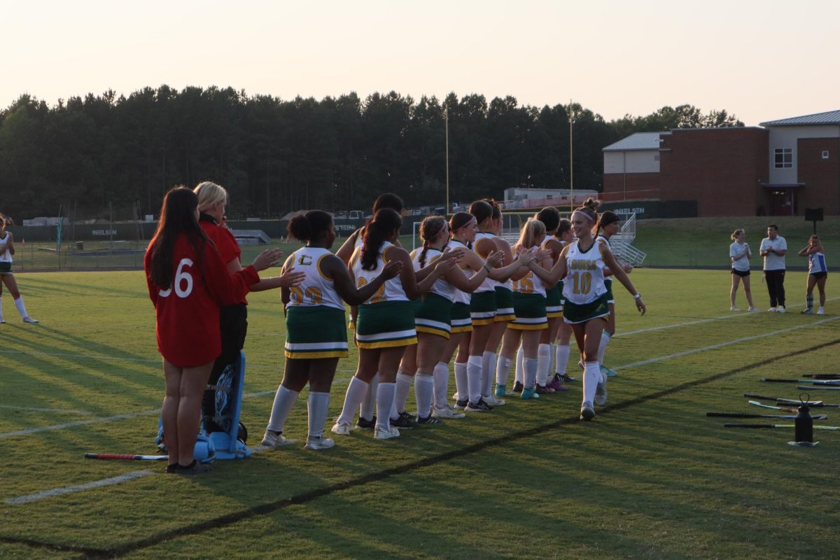 Sophomore Emery Jones high fives her teammates before running onto the field.