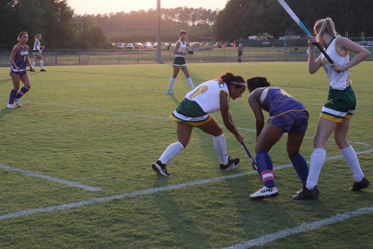 Junior Angelica Monterroza competes with a King George athlete for the field hockey ball.