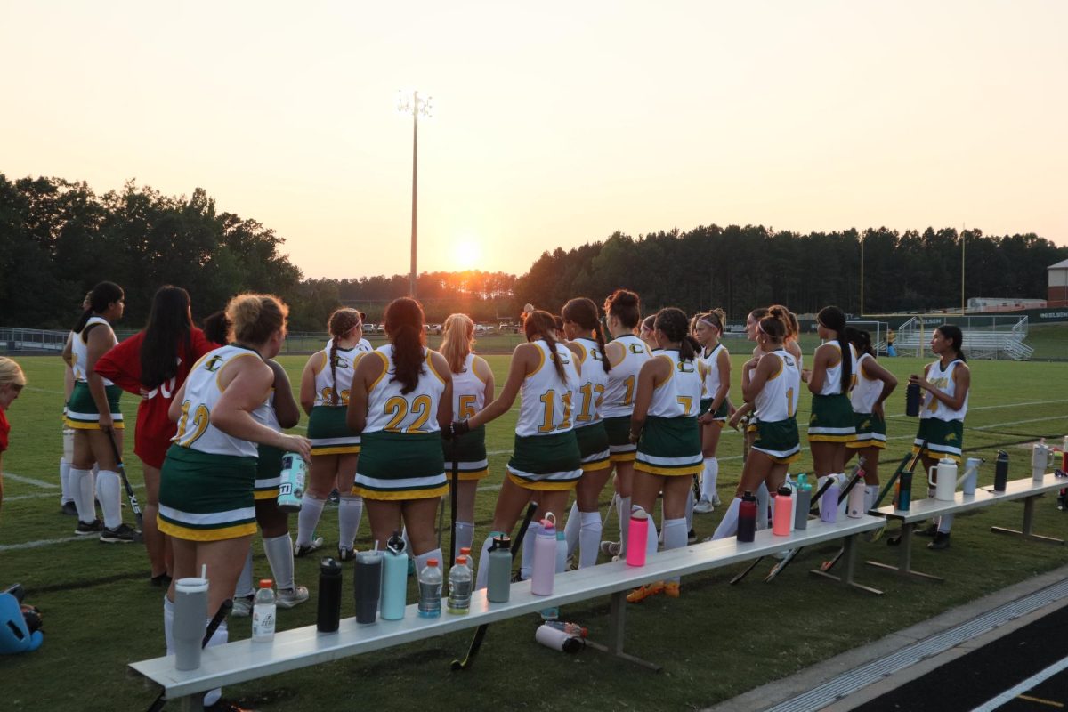 The Varsity girls field hockey team listens to their coach's advice before the game starts.