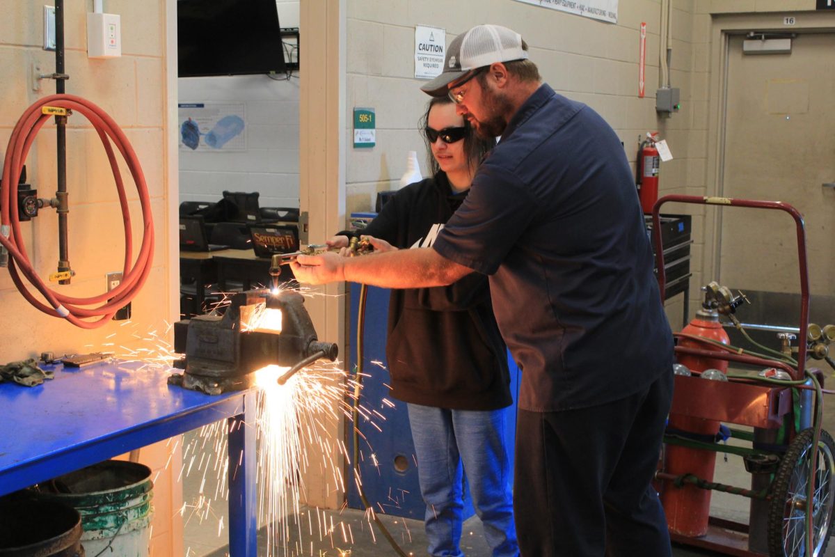 Mr. Galanti’s hands-on approach shows the Auto 1 student how to use a torch.